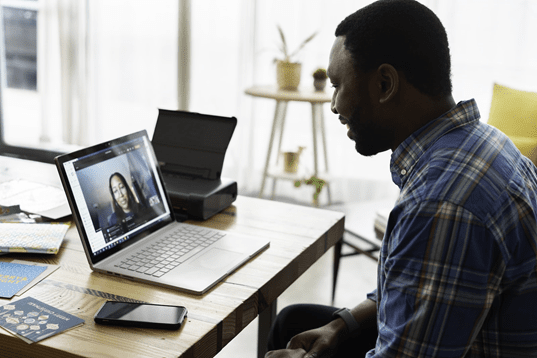 Man on a video call with REALTOR talking about first time home buyers guide.