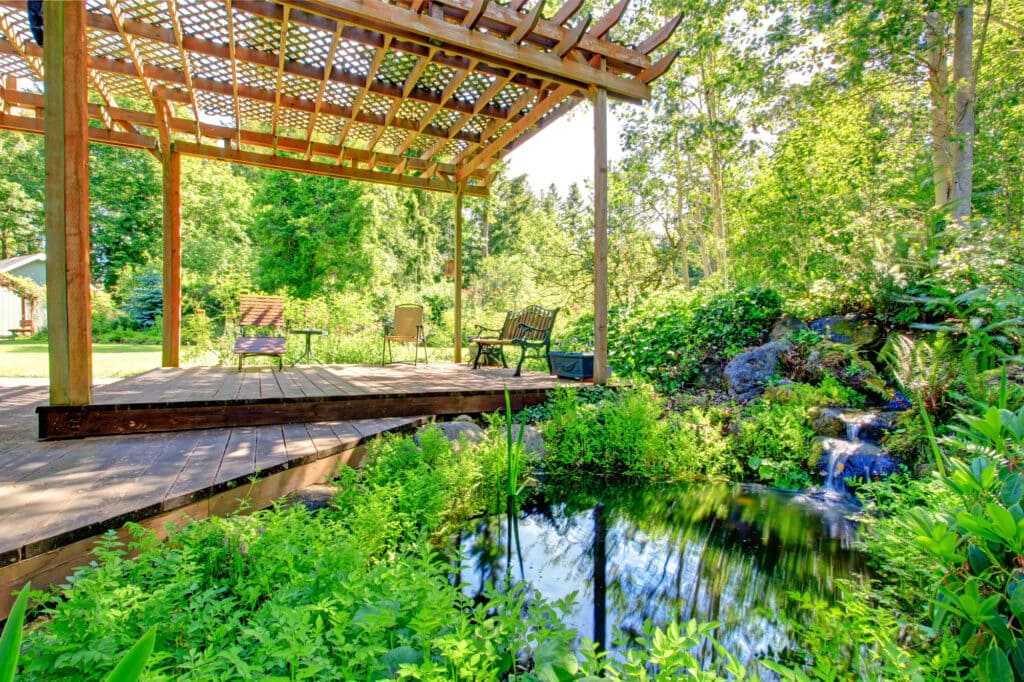 picturesque backyard farm garden with small pond and patio area