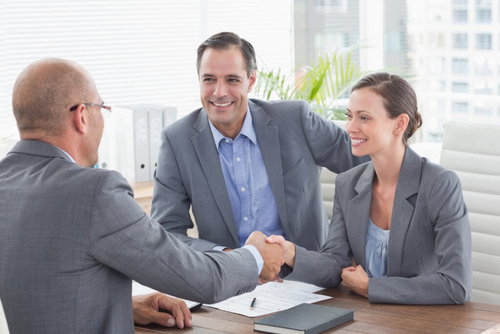 businessman shaking hands with a businesswoman in an office