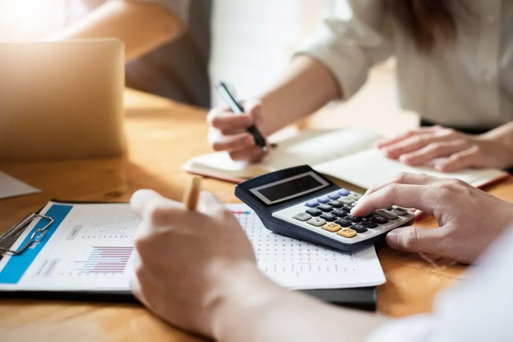 close up businessman and partner using calculator and laptop for