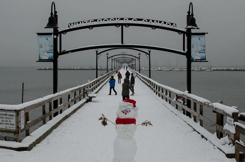 Photo of a snowman infront of the White Rock Pier in British Columbia during winter