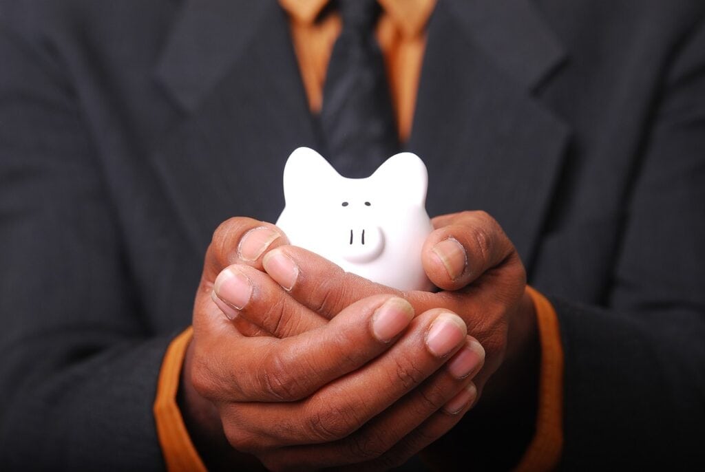 A photo of a man holding a piggy bank